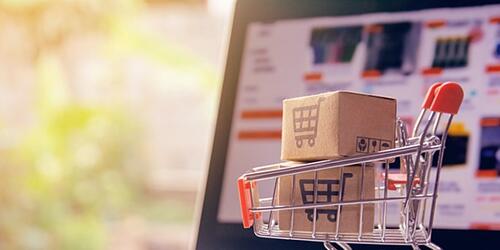 Laptop with a supermarket trolley and boxes for online shopping 